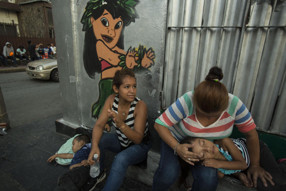Migrants from Honduras wait in the street next to the Mexican Commission for Migrant Assistance office, for their turn to get the documents needed that allows them to stay in Mexico, in Tapachula, early Thursday, June 20, 2019. The flow of migrants into southern Mexico has seemed to slow in recent days as more soldiers, marines, federal police, many as part of Mexico's newly formed National Guard, deploy to the border under a tougher new policy adopted at a time of increased pressure from the Trump administration. (AP Photo/Oliver de Ros)