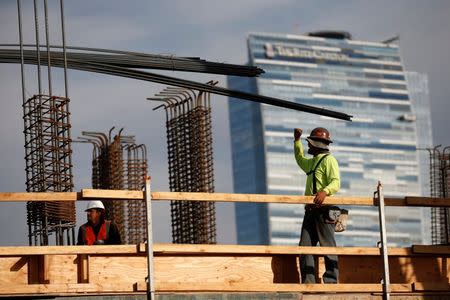 Men work on a construction site for a luxury apartment complex in downtown Los Angeles, California March 17, 2015. REUTERS/Lucy Nicholson