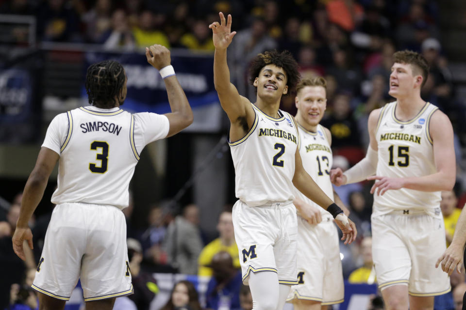 Michigan's Jordan Poole (2) celebrates with teammates including Zavier Simpson (3) after scoring a basket against Florida and drawing a foul, during the second half of a second round men's college basketball game in the NCAA Tournament, in Des Moines, Iowa, Saturday, March 23, 2019. (AP Photo/Nati Harnik)