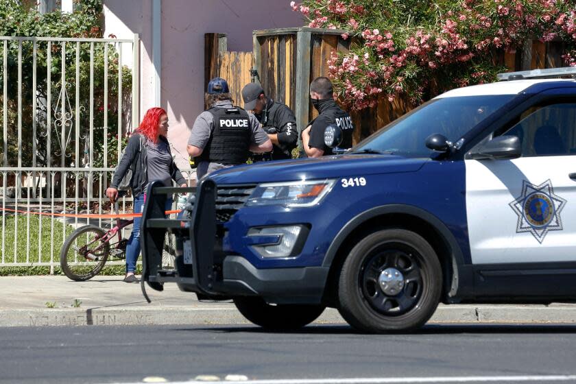 Police officers speak with a local resident as emergency responders respond to a fire at the house of the suspect of a shooting, after nine people were reported dead including the shooter on May 26, 2021 at the San Jose Railyard in San Jose, California. - Multiple people were killed in a shooting Wednesday at a rail yard in California's Bay Area, police said, the latest instance of deadly gun violence in the United States. "I can't confirm the exact number of injuries and fatalities. But I will tell you that there are multiple injuries and multiple fatalities in this case," Russell Davis, a Santa Clara County Sheriff's deputy, told journalists, adding that the gunman was dead. (Photo by Amy Osborne / AFP) (Photo by AMY OSBORNE/AFP via Getty Images)