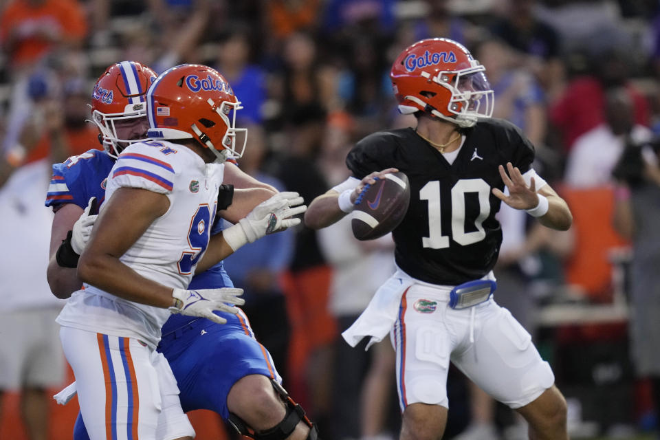 Florida quarterback Jack Miller III (10) looks for a receiver as defensive lineman Tyreik Norwood rushes during the first half of the NCAA college football team's annual Orange and Blue spring game Thursday, April 13, 2023, in Gainesville, Fla. (AP Photo/John Raoux)