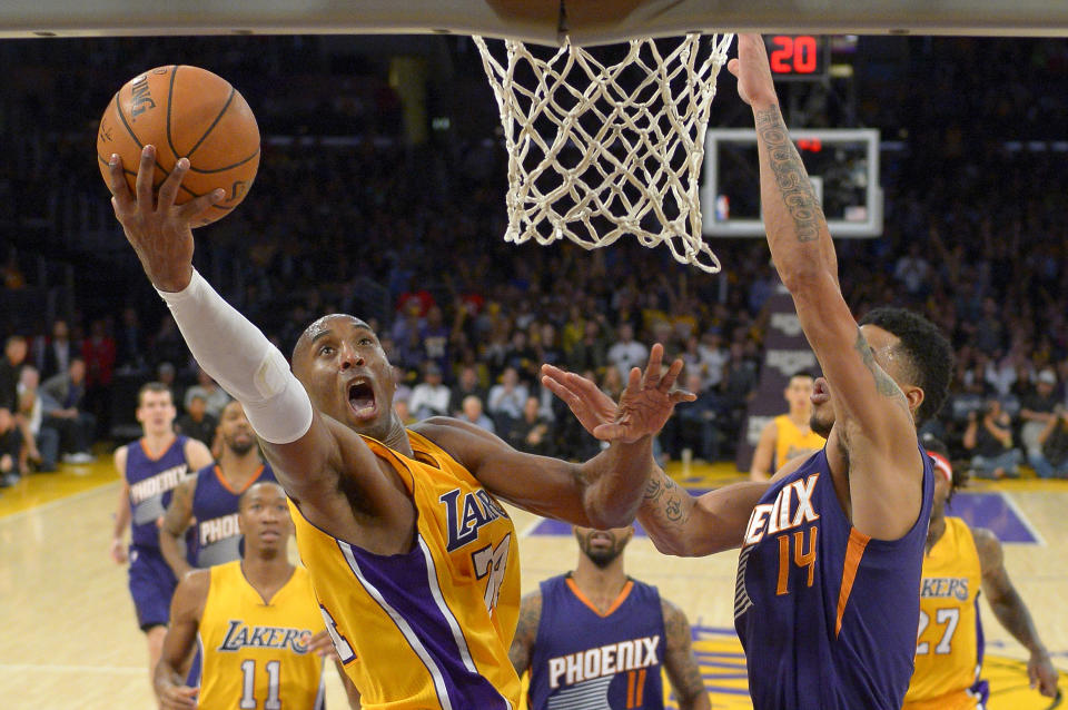 FILE - In this Nov. 4, 2014, file photo, Los Angeles Lakers guard Kobe Bryant shoots as Phoenix Suns guard Gerald Green defends during the second half of an NBA basketball game in Los Angeles. Federal investigators said Wednesday, June 17, 2020, that the pilot of the helicopter that crashed in thick fog, killing Kobe Bryant and seven other passengers, reported he was climbing when he actually was descending. (AP Photo/Mark J. Terrill)