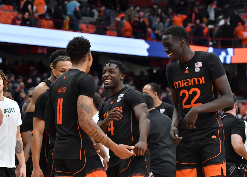 Miami (Fla.) Hurricanes guard Jordan Miller (11) is greeted by guard Bensley Joseph (4) and forward Deng Gak (22) after a win against the Syracuse Orange at the Carrier Dome.