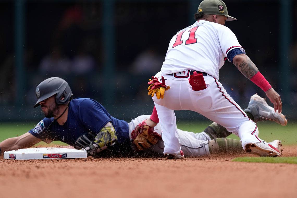 Seattle Mariners&#x002019; Jose Caballero (76) beats the tag from Atlanta Braves shortstop Orlando Arcia (11) as he steals second base in the sixth inning of a baseball game, Sunday, May 21, 2023, in Atlanta. (AP Photo/John Bazemore)