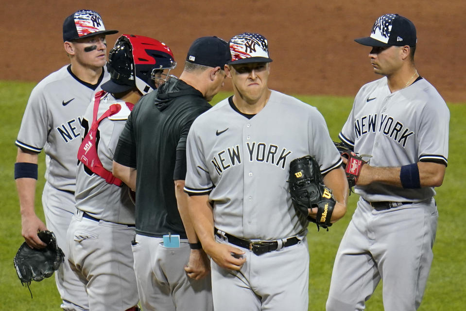 New York Yankees starting pitcher Jameson Taillon, front, walks off the mound after giving the ball to manager Aaron Boone during the sixth inning of the team's baseball game against the Pittsburgh Pirates in Pittsburgh, Tuesday, July 5, 2022. (AP Photo/Gene J. Puskar)