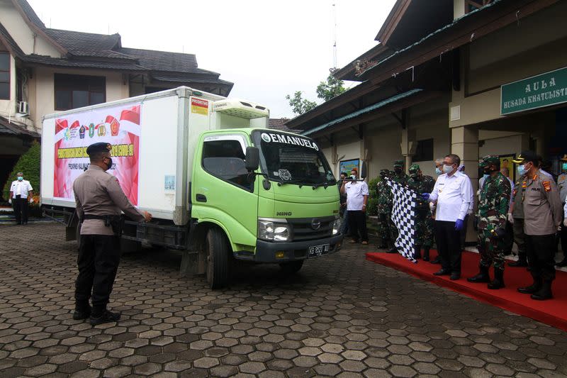 West Kalimantan Governor Sutarmidji holds a flag during a ceremony to start Sinovac's COVID-19 vaccine distribution in Pontianak