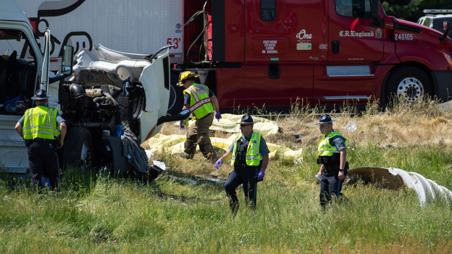 Oregon State Police troopers and firefighters work near the site of a wrecked tractor-trailer Thursday, May 18, 2023,calong Interstate 5 in Albany, Ore. Mulitple people were killed and others hurt in a crash involving multiple vehicles Thursday on Interstate 5 near Albany, Oregon, police said. (Alex Powers/Albany Democrat-Herald via AP)