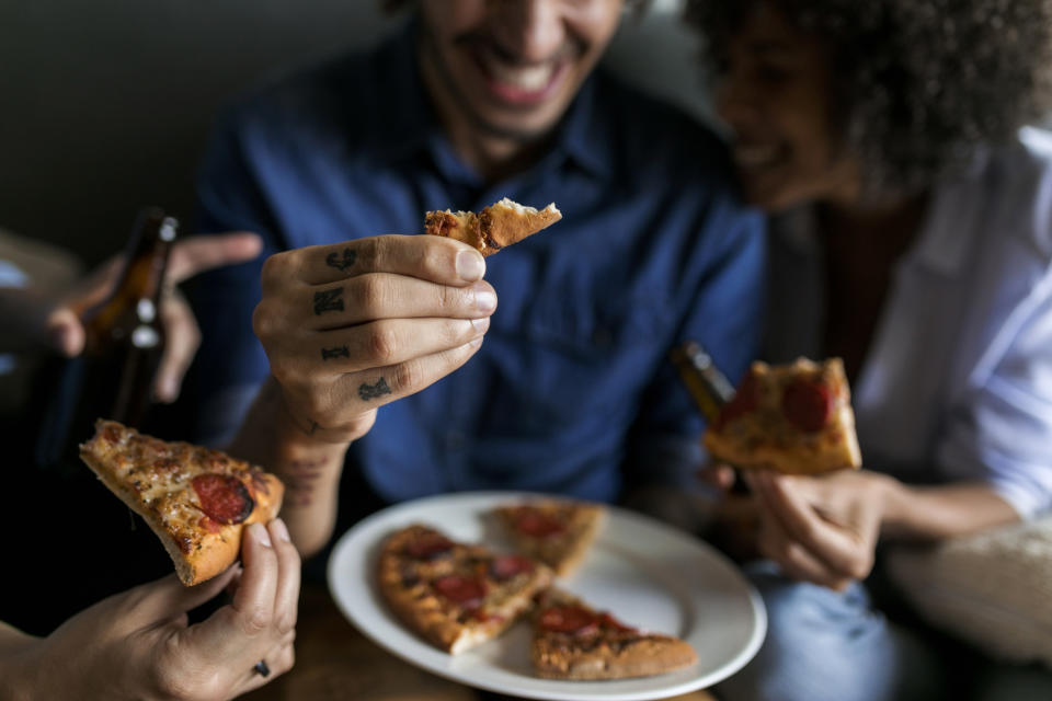 A group of friends eating pizza while out