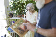 Carolyn and George Spaulding look at family photos in Portland, Ore., Wednesday, July 20, 2022. Their son, Brian, was killed in 2017 and the case remains open. "You want to help but you can't help because it's already done. Your motherhood just sort of stops at that point. You can't mother him because he's not there to mother," she said of the shock of finding her son's body. (AP Photo/Craig Mitchelldyer)