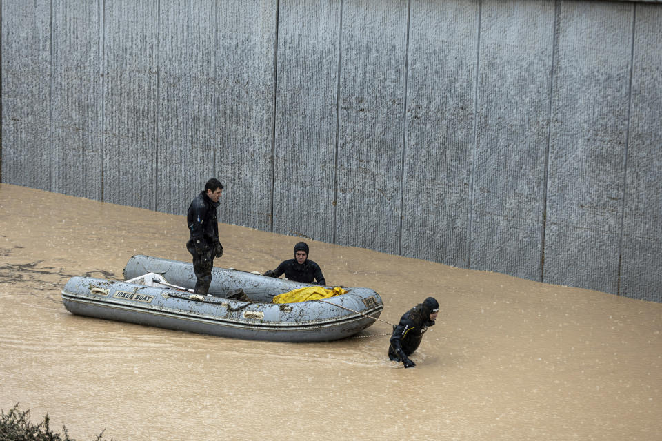 Rescue team members carry the body of a person in a rubber boat during floods after heavy rains in Sanliurfa, Turkey, Wednesday, March 15, 2023. Floods caused by torrential rains hit two provinces that were devastated by last month's earthquake, killing at least 10 people and increasing the misery for thousands who were left homeless, officials and media reports said Wednesday. At least five other people were reported missing. (Ugur Yildirim/DIA via AP)