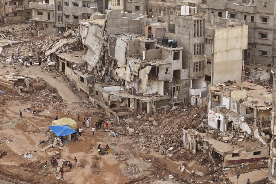 FILE - Rescuers and relatives of victims set up tents in front of collapsed buildings in Derna, Libya, on Sept. 18, 2023. Libya’s chief prosecutor said Monday Sept. 25, 2023 he ordered the detention of eight current and former officials pending his investigation into the collapse of two dams earlier this month, a disaster that sent a wall of water several meters high through the center of a coastal city and left thousands of people dead. (AP Photo/Muhammad J. Elalwany, File)