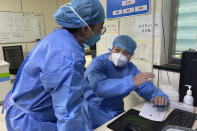 Hospital workers discuss their work at the emergency department of Baigou New Area Aerospace Hospital in Baigou, in northern China's Hebei province on Thursday, Dec. 22, 2022. As China grapples with its first-ever wave of COVID mass infections, emergency wards in the towns and cities to Beijing's southwest are overwhelmed. Intensive care units are turning away ambulances, residents are driving sick relatives from hospital to hospital, and patients are lying on floors for a lack of space. (AP Photo)