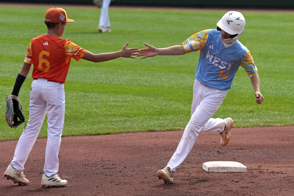 El Segundo, Calif.'s Brody Brooks (14) is greeted by Needville, Texas' Dayln Martin (6) as he rounds second base after hitting a solo home run during the first inning of the United States Championship baseball game at the Little League World Series tournament in South Williamsport, Pa., Saturday, Aug. 26, 2023. (AP Photo/Gene J. Puskar)