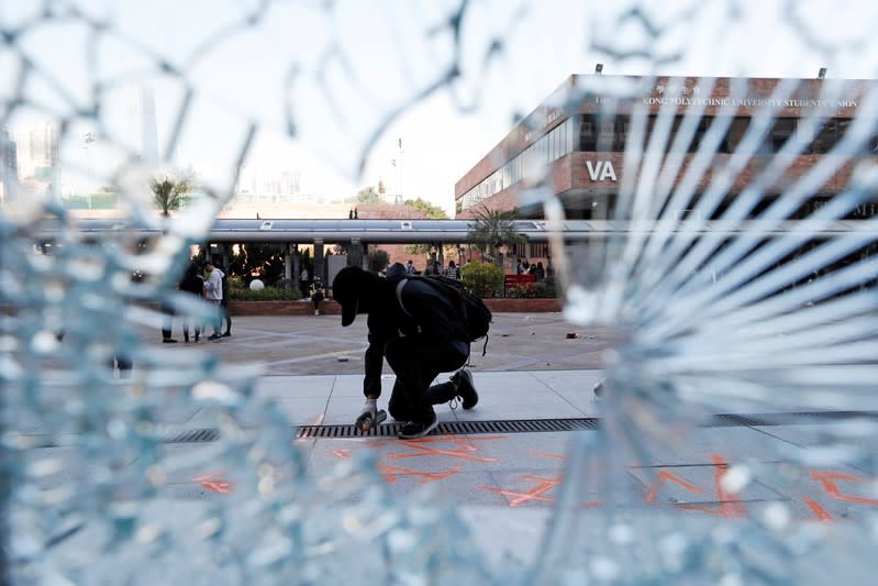 A protester spray paints graffiti at Hong Kong Polytechnic University in Hong Kong