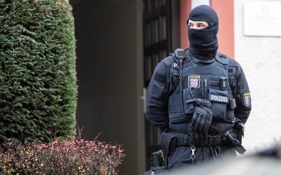 Police officers stand by a searched property in Frankfurt during a raid against so-called 'Reich citizens' in Frankfurt - Boris Roessler/dpa via AP