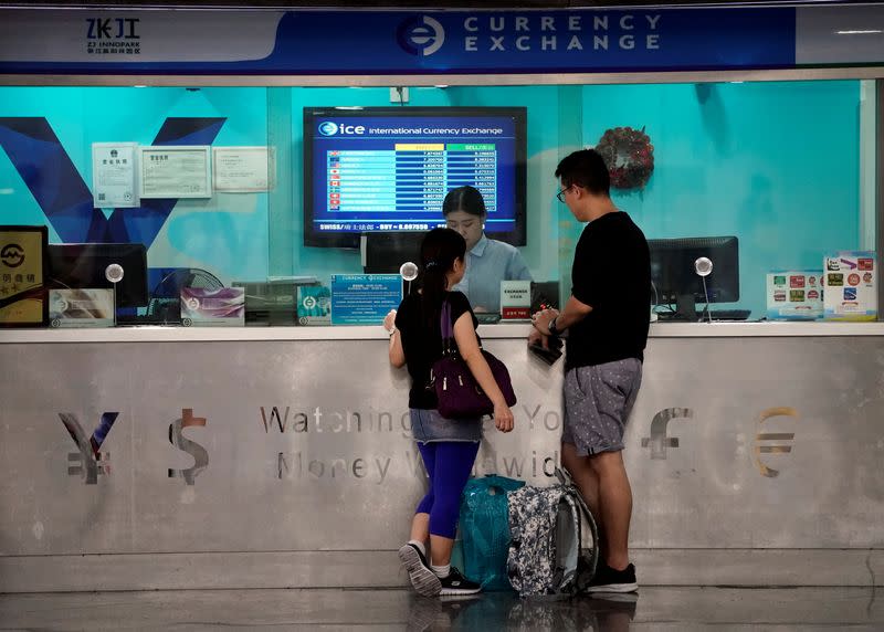 Customers are served at a counter at a currency exchange store in Shanghai