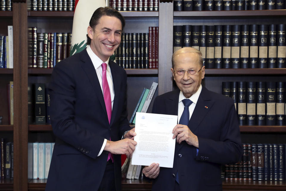 In this photo released by Lebanon's official government photographer Dalati Nohra, Lebanese President Michel Aoun, right, receives from U.S. Envoy for Energy Affairs Amos Hochstein, the U.S.-brokered deal setting a maritime border between Lebanon and Israel, at the presidential palace, in Beirut, Lebanon, Thursday, Oct. 27, 2022. Lebanon signed and delivered its copy of a U.S.-mediated sea border deal with Israel on Thursday to a U.S. mediator, hoping to soon start exploring gas in its southern maritime blocs to bring economic stability to the crisis-ridden country. (Dalati Nohra via AP)