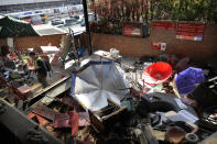 A university staff member walks through debris at Hong Kong Polytechnic University in Hong Kong, Friday, Nov. 29, 2019. Hong Kong police were preparing Friday to reopen access to the university campus after blocking it for 12 days to try to arrest protesters holed up inside. (AP Photo/Vincent Thian)