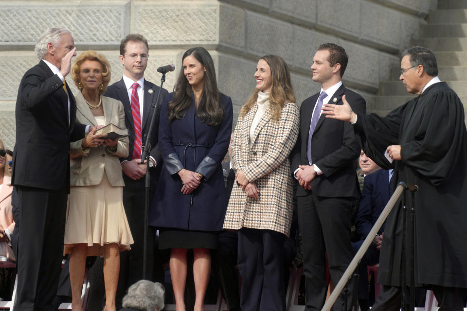 South Carolina Gov. Henry McMaster, left, takes the oath of office administered by state Supreme Court Justice John Kittredge, right, as McMaster's family looks on at his second inaugural on Wednesday, Jan. 11, 2023, in Columbia, S.C. (AP Photo/Meg Kinnard)