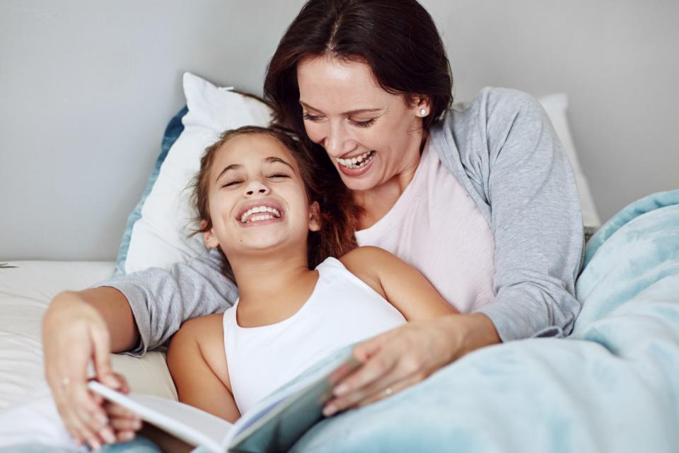 mother reading to daughter in bed