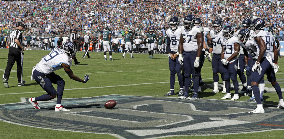 <p>Tennessee Titans wide receiver Tajae Sharpe (19) rolls the football toward his teammates to knock them over like bowling pins as they celebrate a touchdown catch by Sharpe against the Philadelphia Eagles in the second half of an NFL football game Sunday, Sept. 30, 2018, in Nashville, Tenn. (AP Photo/James Kenney) </p>