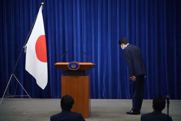 Former Japanese Prime Minister Shinzo Abe bows to the national flag at the start of a press conference at the prime minister official residence in Tokyo, Japan, on Aug. 28, 2020. Abe announced his resignation due to health concerns. (Photo: Franck Robichon/Pool/Anadolu Agency via Getty Images)