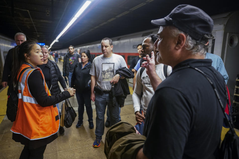 An MTA employee informs commuters the their trains are not in service due to heavy rains, Friday, Sept. 29, 2023, at Grand Central Terminal in New York. (AP Photo/Mary Altaffer)