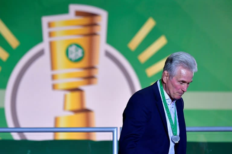 Bayern Munich's German head coach Jupp Heynckes walks with his medal past a logo of the German Cup DFB Pokal after the German Cup DFB Pokal final football match FC Bayern Munich vs Eintracht Frankfurt at the Olympic Stadium in Berlin on May 19, 2018