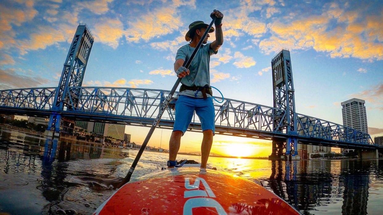 Times-Union columnist Mark Woods paddleboards through downtown Jacksonville at sunrise. Fifty years ago, before the Clean Water Act passed in 1972, the St. Johns River was so polluted that health officials warned that one could contract 27 communicable diseases by swimming across the river near the Main Street Bridge.