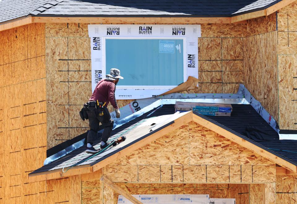 A roofer lays shingles at Ivory Homes’ Gabler’s Grove development in Magna on Tuesday, July 25, 2023. | Scott G Winterton, Deseret News