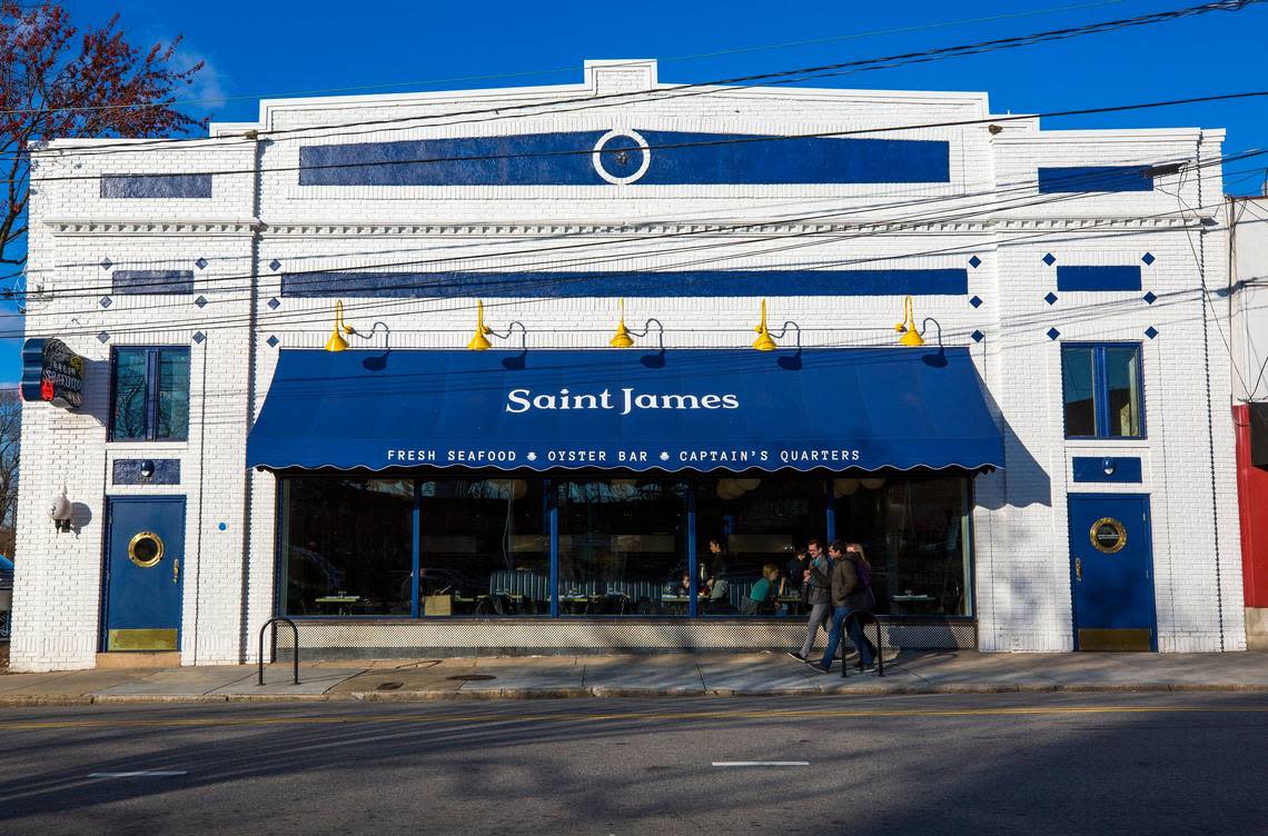 Three pedestrians make their way past Saint James Seafood on Thursday, Mar. 14, 2018, in Durham, NC.