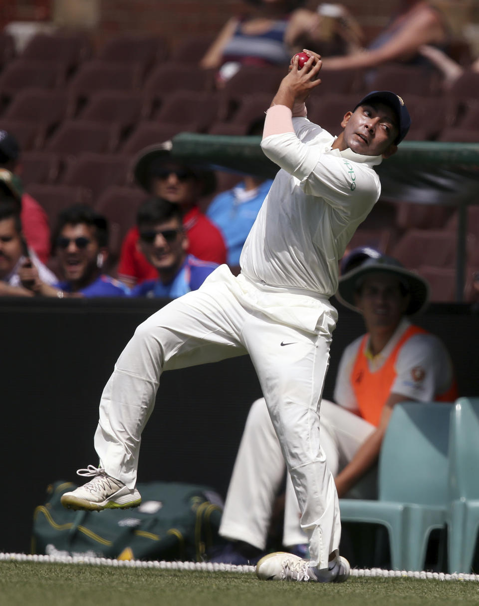 India's Prithvi Shaw rolls his ankle as he attempts to catch out CA XI's Max Bryant during their tour cricket match in Sydney, Friday, Nov. 30, 2018. (AP Photo/Rick Rycroft)