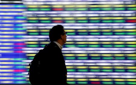A man walks past an electronic stock quotation board outside a brokerage in Tokyo, Japan, November 13, 2018.   REUTERS/Toru Hanai