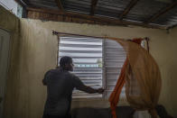 Nelson Cirino refuerza las ventanas de su casa ante los vientos del huracán Fiona, el domingo 18 de septiembre de 2022, en Loiza, Puerto Rico. (AP Foto/Alejandro Granadillo)