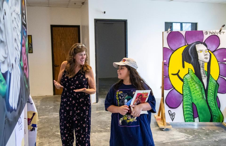 Event coordinator April Lopez talks with 10-year-old Nancy Cuevas of Indio about an art piece on display in the Art Speaks gallery at Music Changing Lives in Thousand Palms, Calif., Saturday, Oct. 1, 2022. Lopez left a job as a funeral director after the stress from the job wore into her especially hard after the pandemic. Taking a leap of faith she recently joined the Music Changing Lives staff and immediately felt at home. "This is where I'm meant to be," she said with a rejuvenated smile.