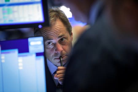 FILE PHOTO: Traders work on the floor at the NYSE in New York