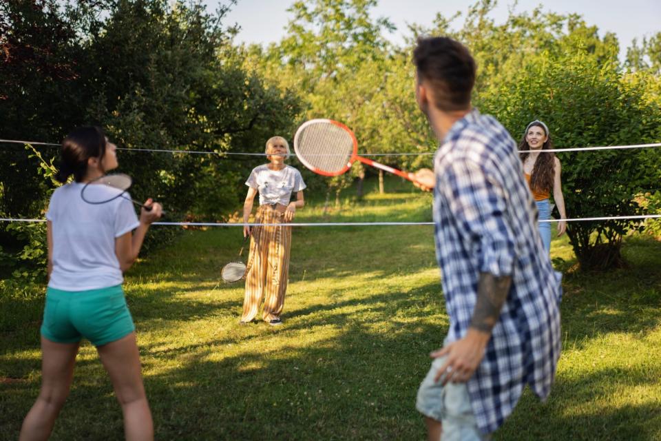 group of friends playing backyard badminton