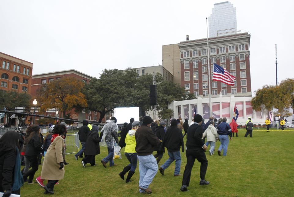 Members of the public race for good positions on Dealey Plaza prior to 50th anniversary ceremonies of JFK's assassination in Dallas