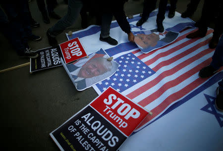 Palestinian protesters prepare to burn posters depicting U.S. President Donald Trump and Israeli Prime Minister Benjamin Netanyahu during a protest against Trump's decision to recognize Jerusalem as the capital of Israel, in Gaza City December 7, 2017. REUTERS/Mohammed Salem