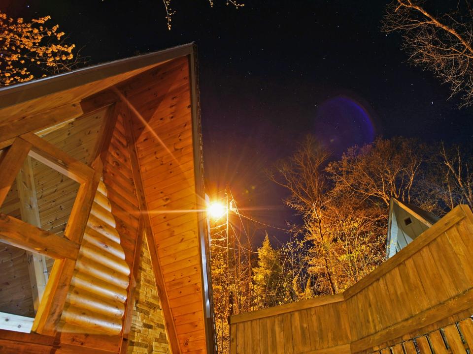 Cabins in the mountains seen at night with a few stars above.