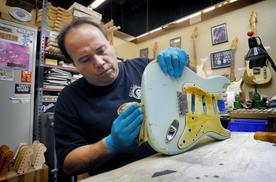 Fender Custom Shop Master Builder John Cruz works on a heavily-used Fender Stratocaster body at the Fender factory in Corona, Calif. on Tuesday, Oct. 15, 2013. Leo Fender developed the instrument in a small workshop in Fullerton, Calif. six decades ago. (AP Photo/Matt York)