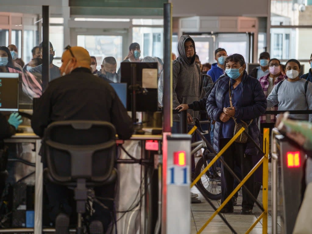 File: People wait in line to clear customs and enter the United States at the Paso Del Norte Port of Entry in downtown El Paso, Texas on 8 November 2021.  Texas has reported its first recorded death due to Omicron variant (AFP via Getty Images)