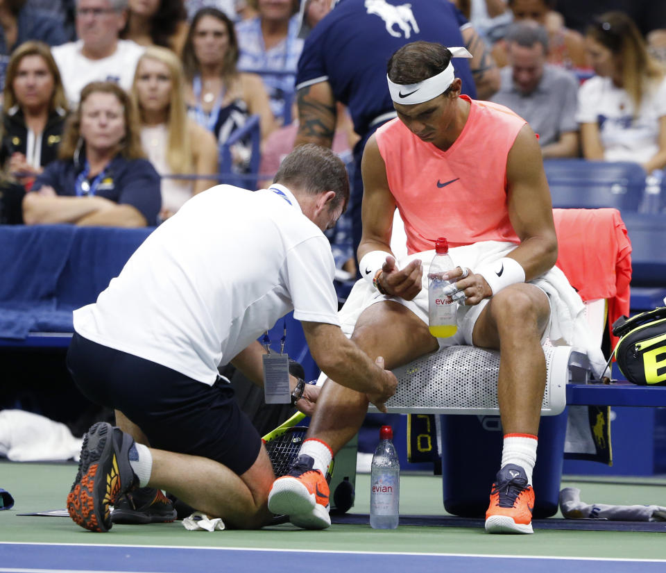 Rafael Nadal, of Spain, is seen by a trainer during the third round of the U.S. Open tennis tournament against Karen Khachanov, of Russia, Friday, Aug. 31, 2018, in New York. (AP Photo/Jason DeCrow)