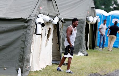 A Haitian refugee walks from his tent, one of the many set up by the Canadian Armed Forces to deal with the influx of asylum seekers at border in Lacolle, Quebec, Canada August 10, 2017. REUTERS/Christinne Muschi