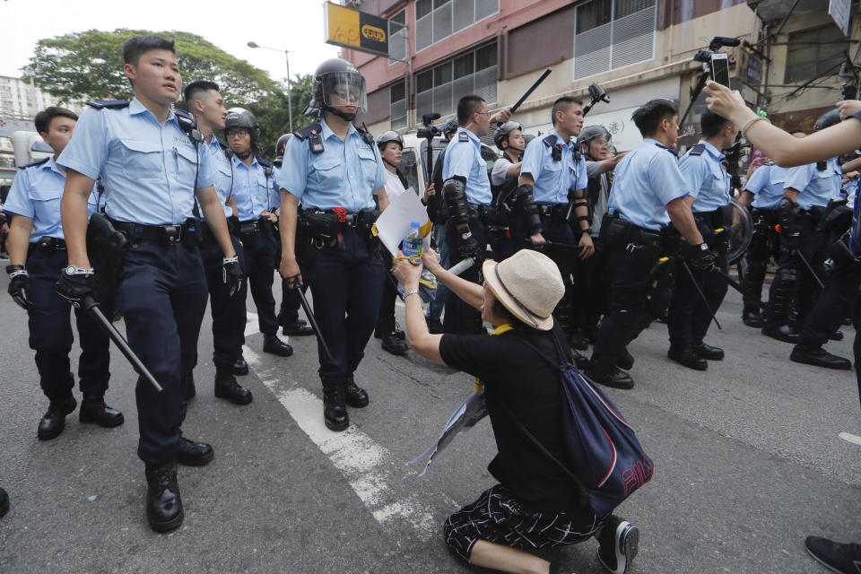 FILE - In this July 31, 2019, file photo, a supporter begs police officer not to attack protesters in Hong Kong. China’s central government has dismissed Hong Kong pro-democracy protesters as clowns and criminals while bemoaning growing violence surrounding the monthslong demonstrations. (AP Photo/Kin Cheung, File)