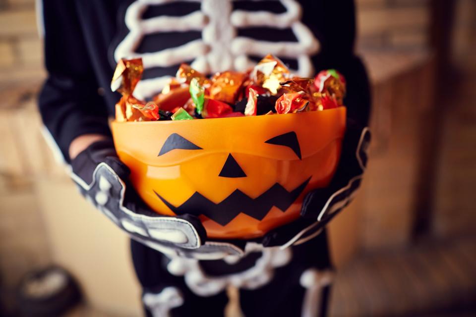 <p>Grab a bucket of relatively flat <a href="https://www.goodhousekeeping.com/holidays/halloween-ideas/news/a40935/buy-the-cheapest-halloween-candy/" rel="nofollow noopener" target="_blank" data-ylk="slk:Halloween candies;elm:context_link;itc:0;sec:content-canvas" class="link ">Halloween candies</a> (think rectangular ones Kit-Kat or Hershey's bars) and take turns stacking them on top of one another. The first person to knock down the stack loses — and the winners get to split the sweet loot. </p>