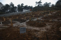 FILE - In this Sunday, March 29, 2020, file photo, freshly-dug graves at a newly prepared cemetery the authorities have set aside for the burial of COVID-19 coronavirus victims, in Istanbul's Beykoz district. When Turkey changed the way it reports daily COVID-19 infections, it confirmed what medical groups and opposition parties have long suspected — that the country is faced with an alarming surge of cases that is fast exhausting the Turkish health system. The official daily COVID-19 deaths have also steadily risen to record numbers in a reversal of fortune for the country that had been praised for managing to keep fatalities low. With the new data, the country jumped from being one of the least-affected countries in Europe to one of the worst-hit.(AP Photo/Emrah Gurel, File)