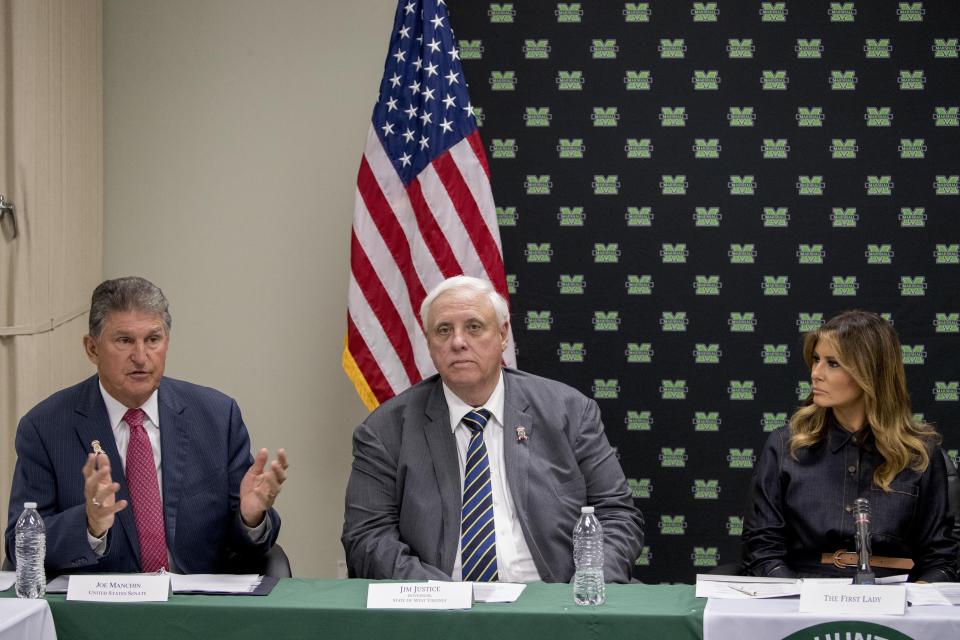 Sen. Joe Manchin, D-W.Va., left, accompanied by West Virginia Gov. Jim Justice, center, and First lady Melania Trump, right, speaks at a roundtable on the opioid epidemic at Cabell-Huntington Health Center in Huntington, WVa., Monday, July 8, 2019. (AP Photo/Andrew Harnik)