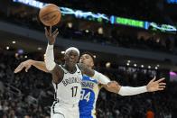 Brooklyn Nets' Dennis Schroder is fouled by Milwaukee Bucks' Giannis Antetokounmpo during the first half of an NBA basketball game Thursday, March 21, 2024, in Milwaukee. (AP Photo/Morry Gash)