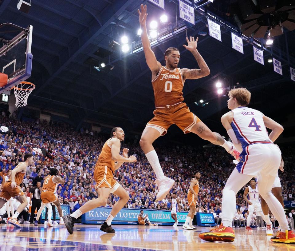 Kansas guard Gradey Dick, right, looks to pass as Texas forward Timmy Allen goes high to defend during the first half Monday night at Allen Fieldhouse. “That’s not Texas basketball," Allen said after the 88-80 loss. "How hard is it to win in this league? It’s brutal. But I’m having the time of my life.”